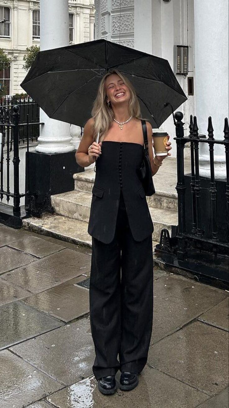 20 Chic Rainy Day Outfits That Make Bad Weather Look Surprisingly Stylish - 8. Sleeveless Tailoring under a Giant Umbrella 1